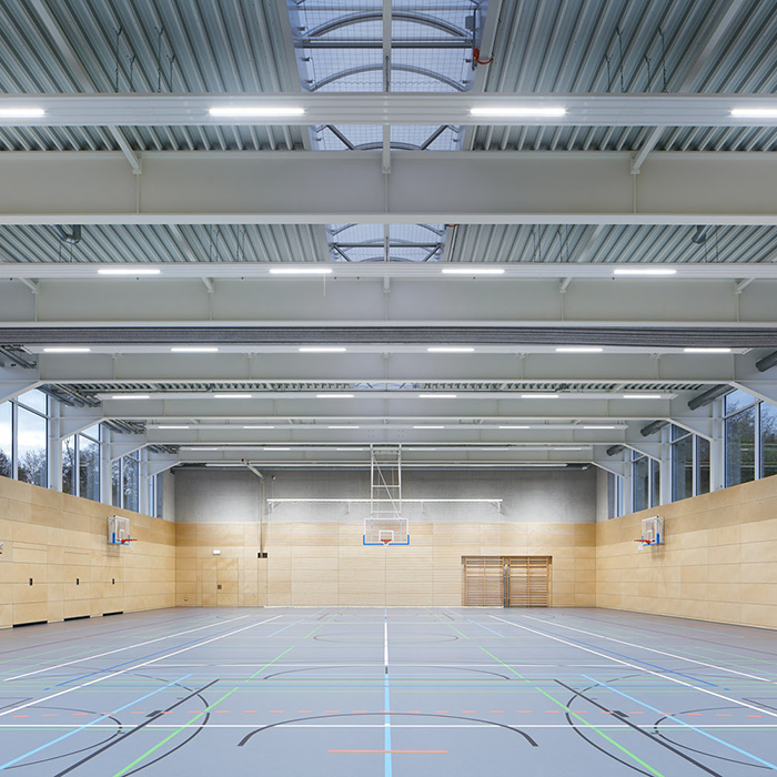 Helle Sporthalle mit Holzvertafelung an den Wänden