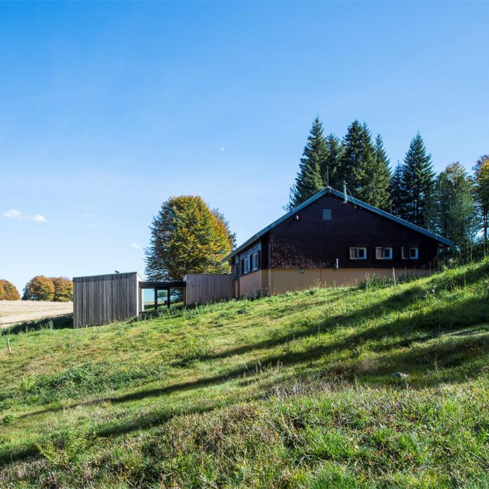 Das moderne Holzgebäude passt sich gut der grünen Landschaft an